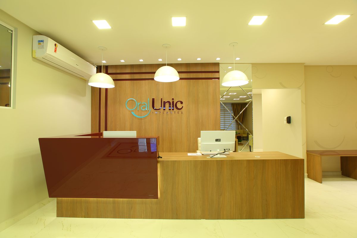 Recepção da Oral Unic Lajeado com o logo da rede no balcão